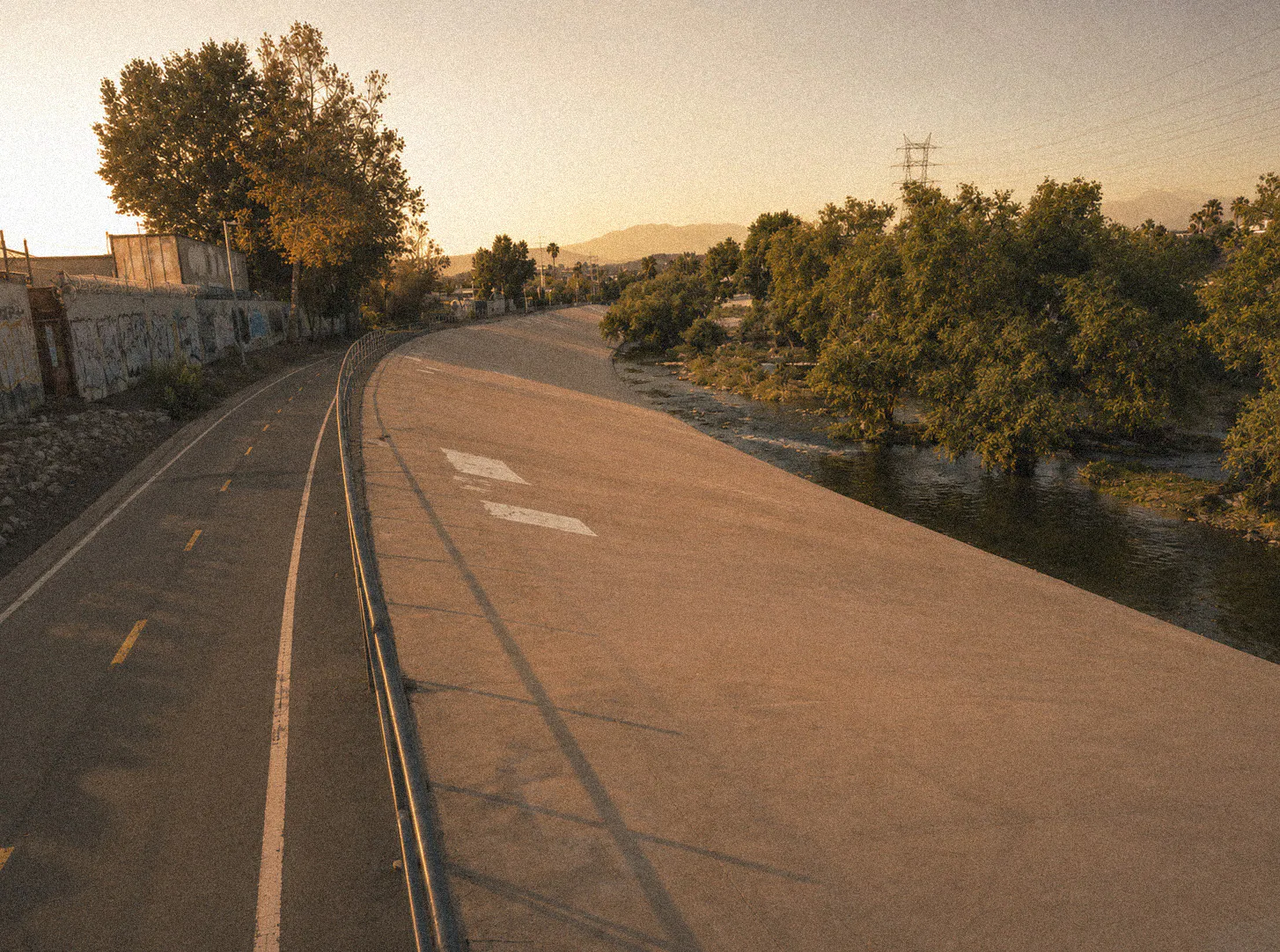 The LA River bike path curving alongside the river and trees